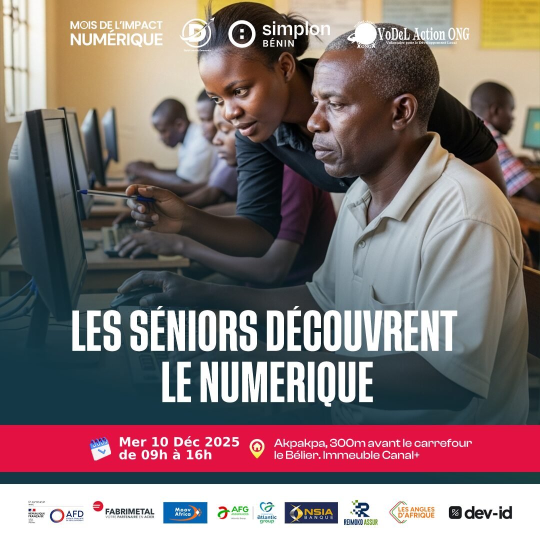 Une jeune femme aide un homme senior devant un ordinateur en salle informatique.